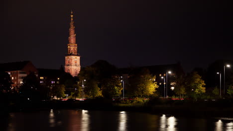 paisaje urbano nocturno de copenhague con el reflejo de la iglesia de la aguja barroca iluminada