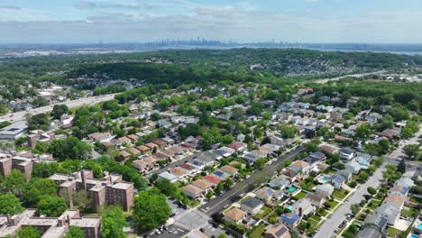 aerial view of suburb neighborhood on staten island with greebelt forest and skyline of manhattan in background - new york city,usa