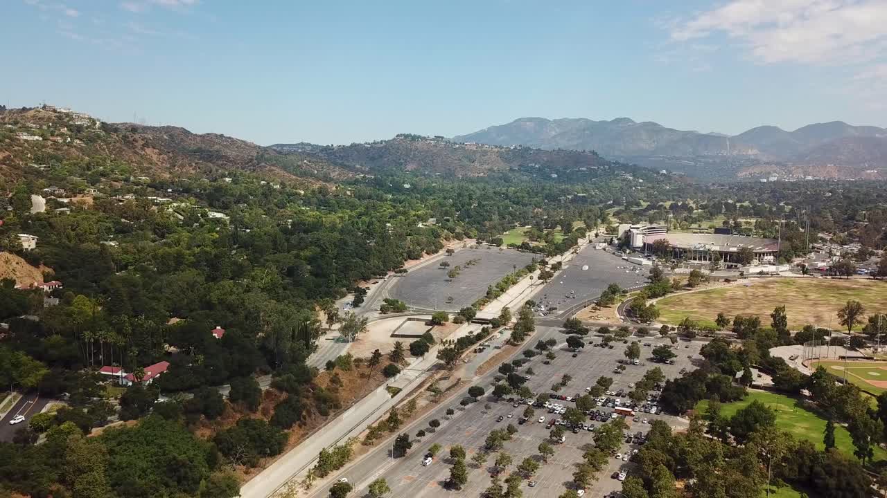 Parking area of rose bowl football stadium in Pasadena, California, USA. Aerial wide shot. Empty area. Sunny summer day with Angeles National Forest in background