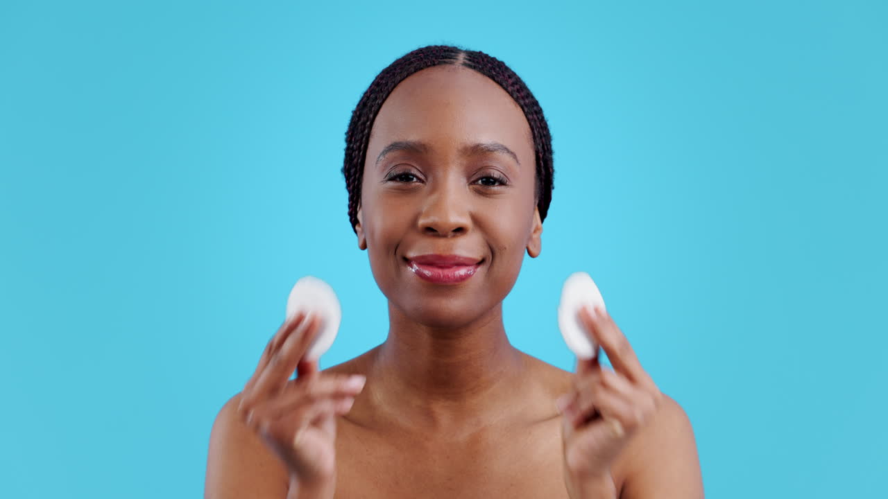 African woman, cotton pad and skincare in studio