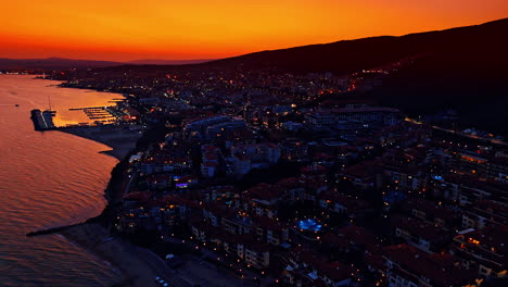 Night view of Sveti Vlas, Bulgaria at night. Aerial perspective on the multiple hotels located on the slopes of the mountains. Orange sky at backdrop