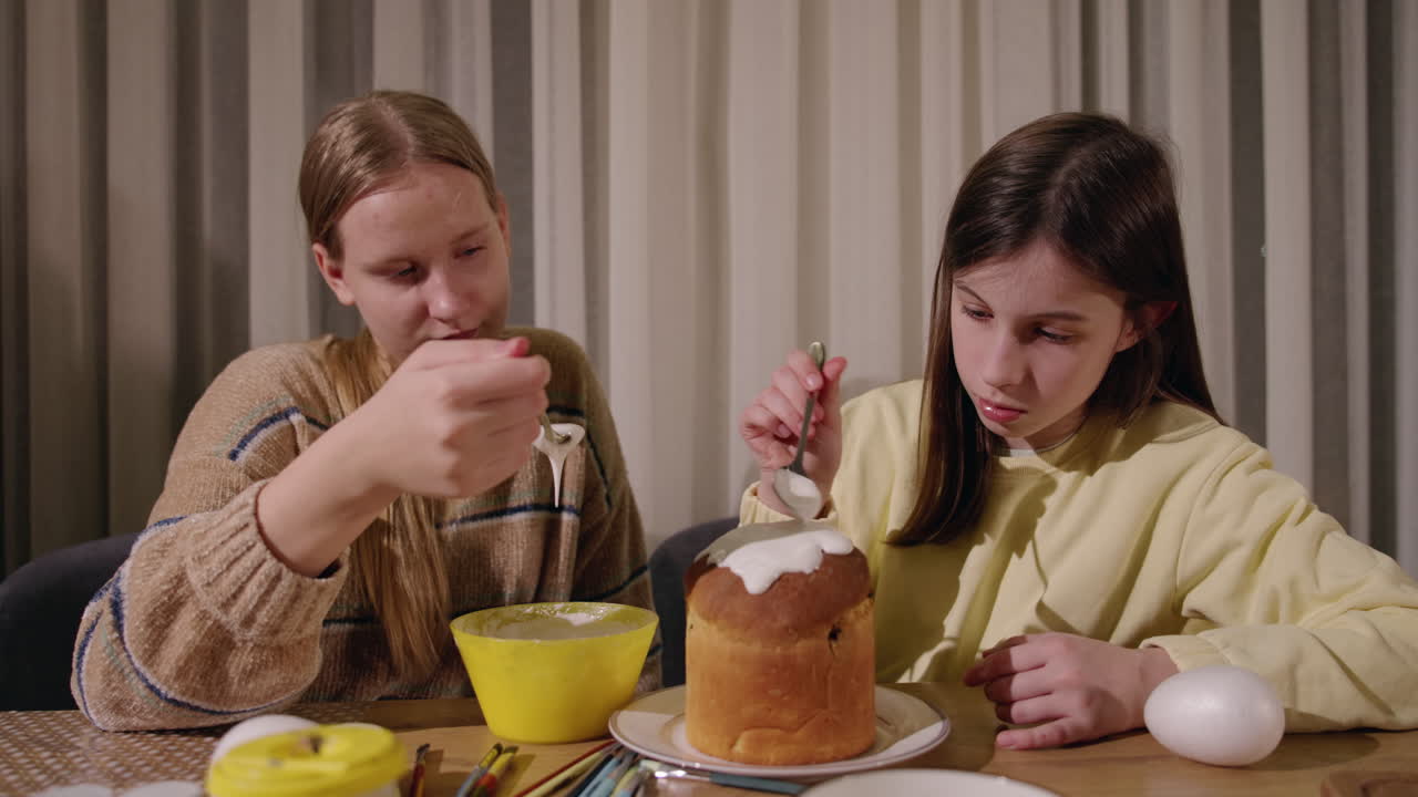 девочки украшают пасхальный хлеб.