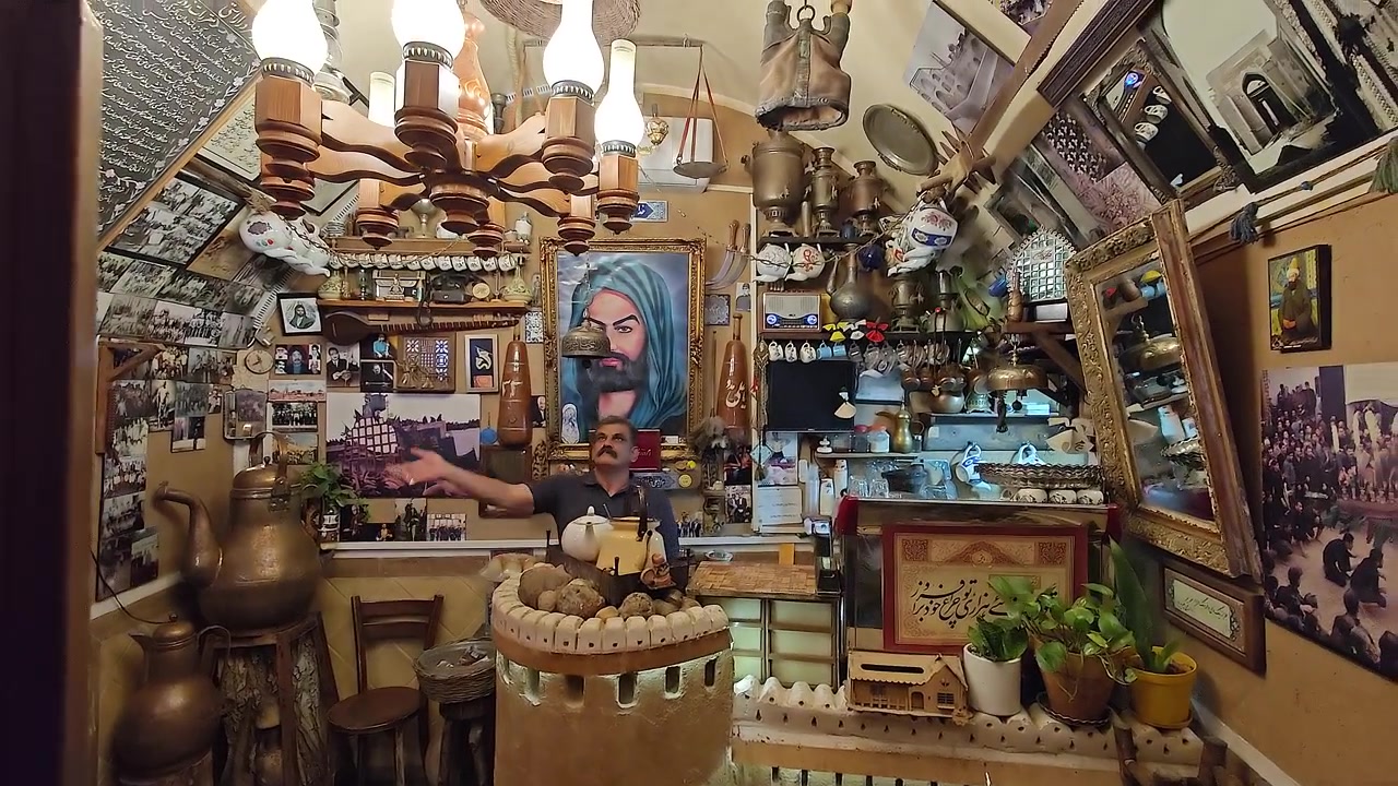 Uomo in piedi in una casa da tè tradizionale iraniana