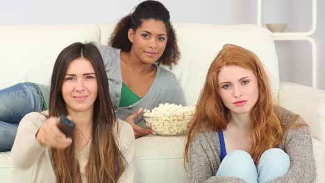 amigos jóvenes viendo la televisión comiendo palomitas de maíz