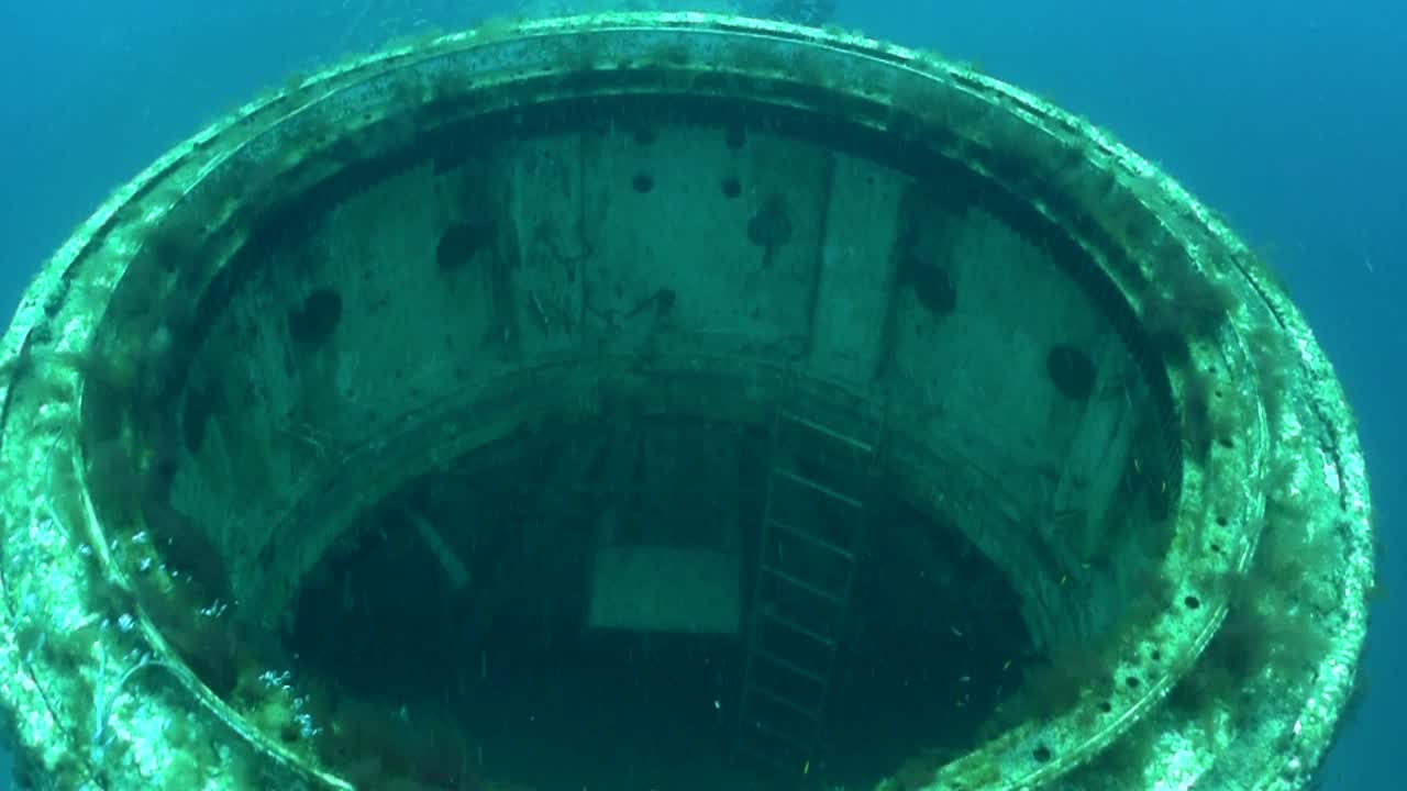 잠수부들이 난파선 주위를 헤엄치고 있다