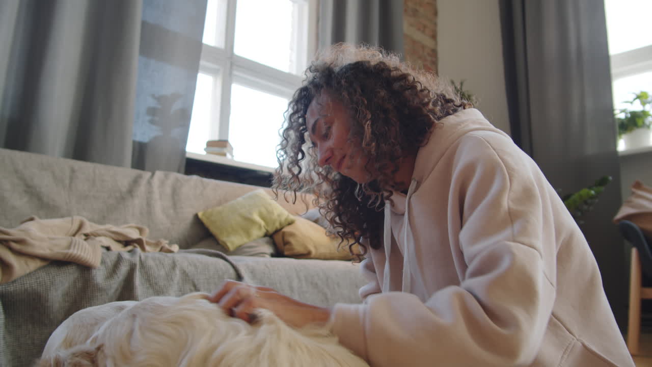 mujer jugando con un golden retriever feliz en la sala de estar