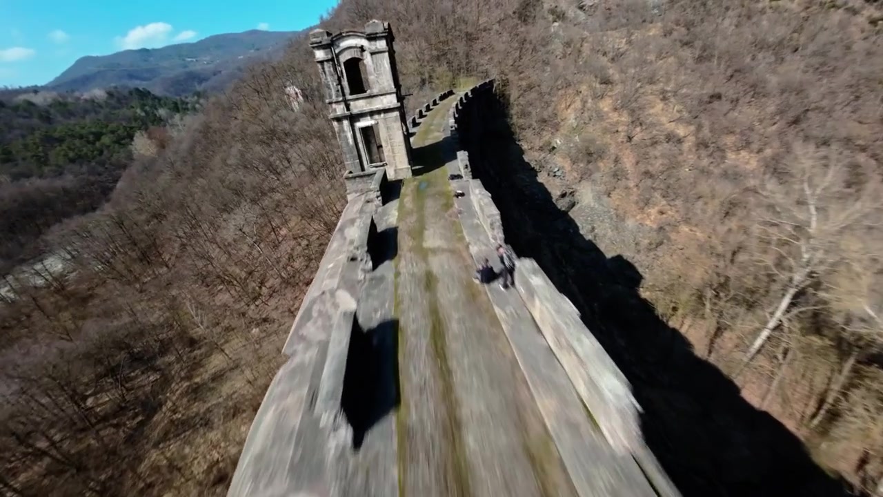 Vista aerea di una diga abbandonata in una foresta d'inverno, che evoca mistero.