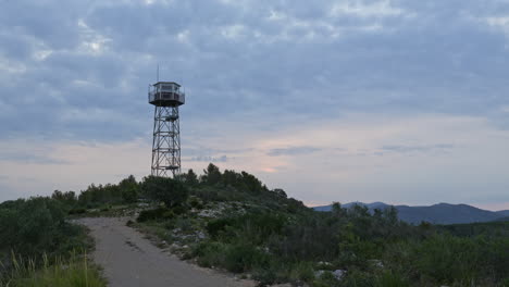 Zeitraffer-Fängt-Den-Turm-Ein,-Während-Ein-Mann-Vor-Dem-Morgenhimmel-Auf-Und-Ab-Klettert