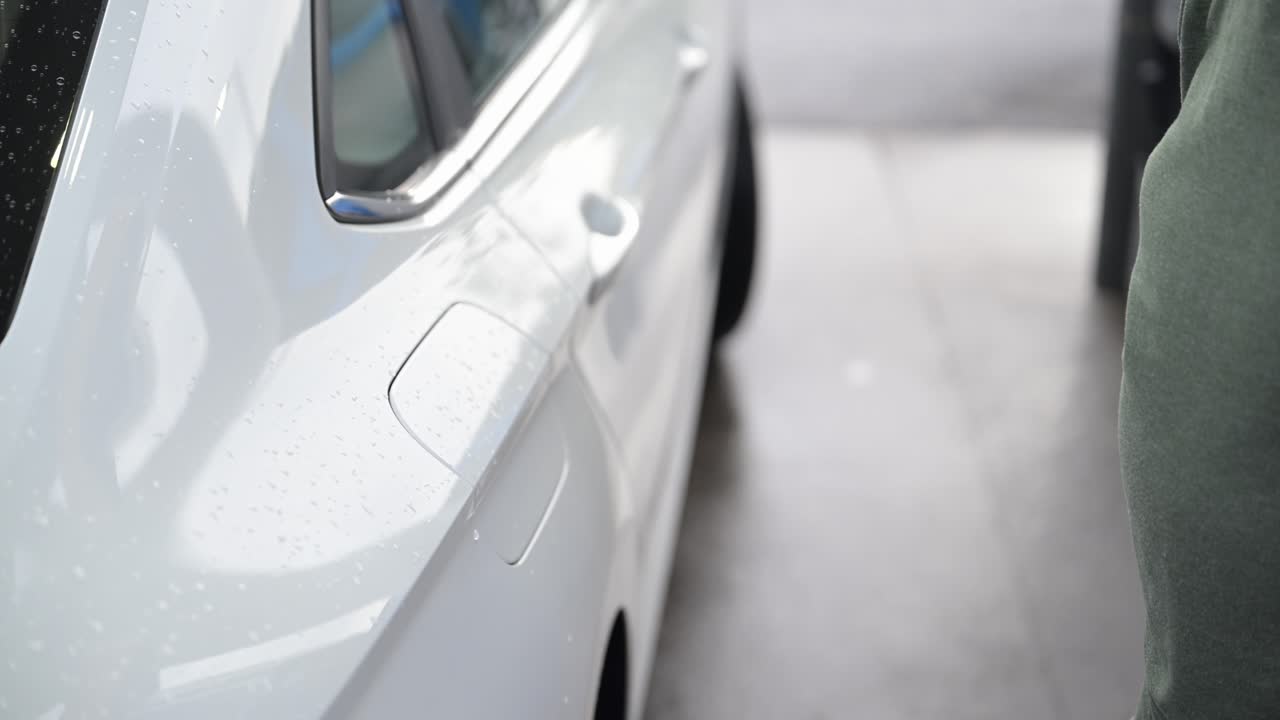 고령 시민 이 주유소 에서 주유 한 후 차 에 가스  을 다시 붙이고 있다