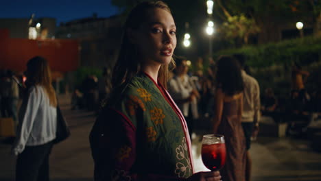 clubbing girl enjoy street entertainment dancing at party with cocktail close up