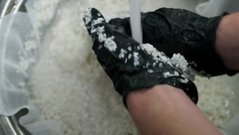 el cocinero lava el arroz con agua del grifo. persona que prepara a mano, lava, agita, arroz tradicional asiático