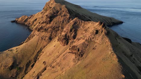 drone flying next to the ridge of a dry and rocky island