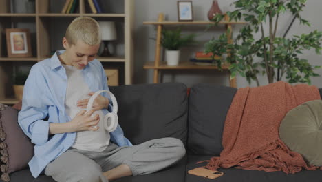 Pregnant woman listening to music on sofa
