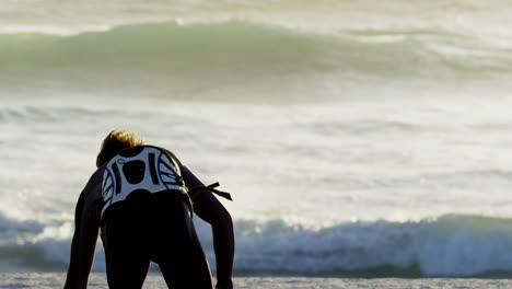 männlicher surfer hält ein surfbrett am strand 4k