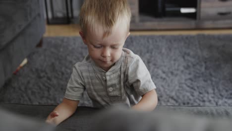 Young-boy-playing-at-home-with-toy-truck