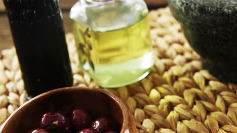 Mortar-and-pestle,-bowl-of-red-olives,-olive-oil