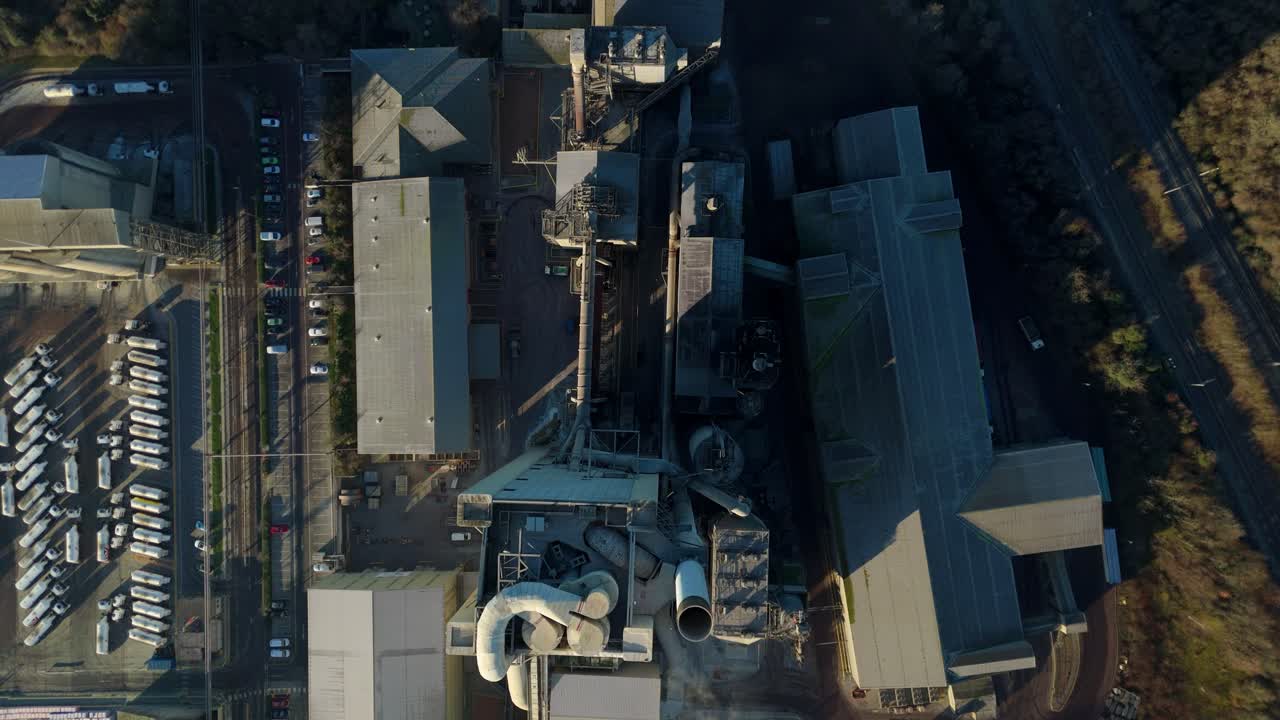 Mjuk drönarglidning från luften över de komplexa industriella rörledningarna och ugnarna på en cementanläggning