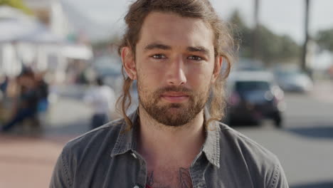 close up portrait of caucasian young man looking serious at camera attractive male tourist on urban beachfront street