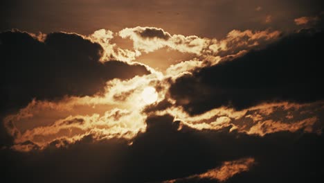 Dramatic-Sunset-Behind-Dark-Backlit-Clouds-Silhouette---Bright-Hot-Shining-Sun-Disk-Cinematic-Scenic-Sunrise-Timelapse-4K