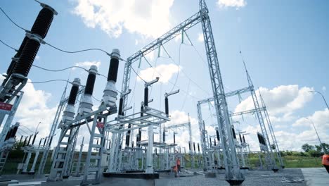 many high voltage electrical insulators in power substation against blue sky background