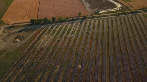 Vista-Aérea-De-Una-Enorme-Estación-Base-De-Granja-Fotovoltaica-Para-El-Suministro-De-Energía-Verde-En-El-Campo-De-Tierras-Agrícolas