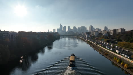 Lastkahn,-Der-Auf-Dem-Fluss-La-Seine-Fährt,-Im-Hintergrund-Das-Pariser-Geschäftsviertel