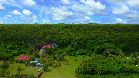 Un-Dron-Captura-Una-Toma-Sobre-Una-Playa-Tropical,-Mostrando-Las-Aguas-Cristalinas,-Las-Playas-De-Arena-Y-Las-Casas-En-La-Orilla,-Y-Luego-Revelando-El-Enorme,-Exuberante-Y-Verde-Bosque-Que-Hay-Detrás-Durante-El-Día