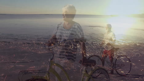 retiree couple holding bicycles on sunset beach, displaying animated heart icon and health chart