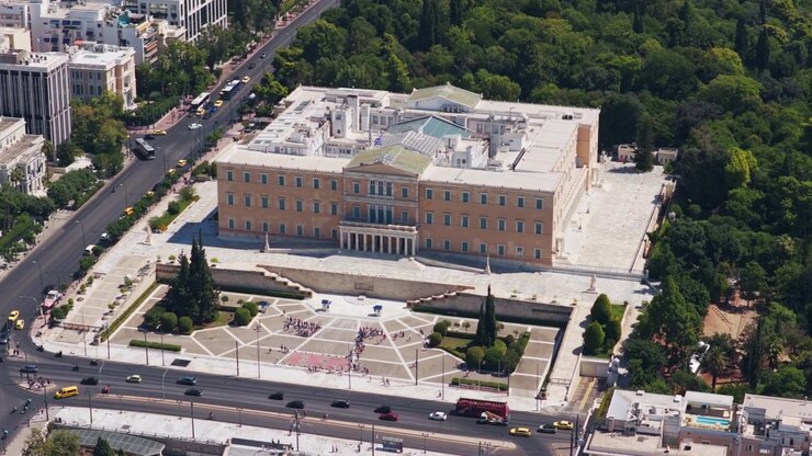 Veduta aerea del palazzo del Parlamento ellenico, della Tomba del Milite Ignoto in Piazza Syntagma e del Giardino Nazionale ad Atene, Grecia, con il traffico urbano che scorre sulla strada