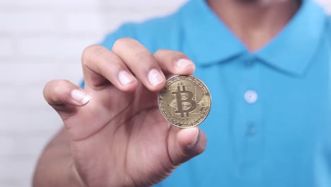 person holding a bitcoin coin