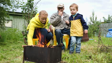 Mutter,-Sohn-Und-Opa-Am-Feuer-Im-Hof