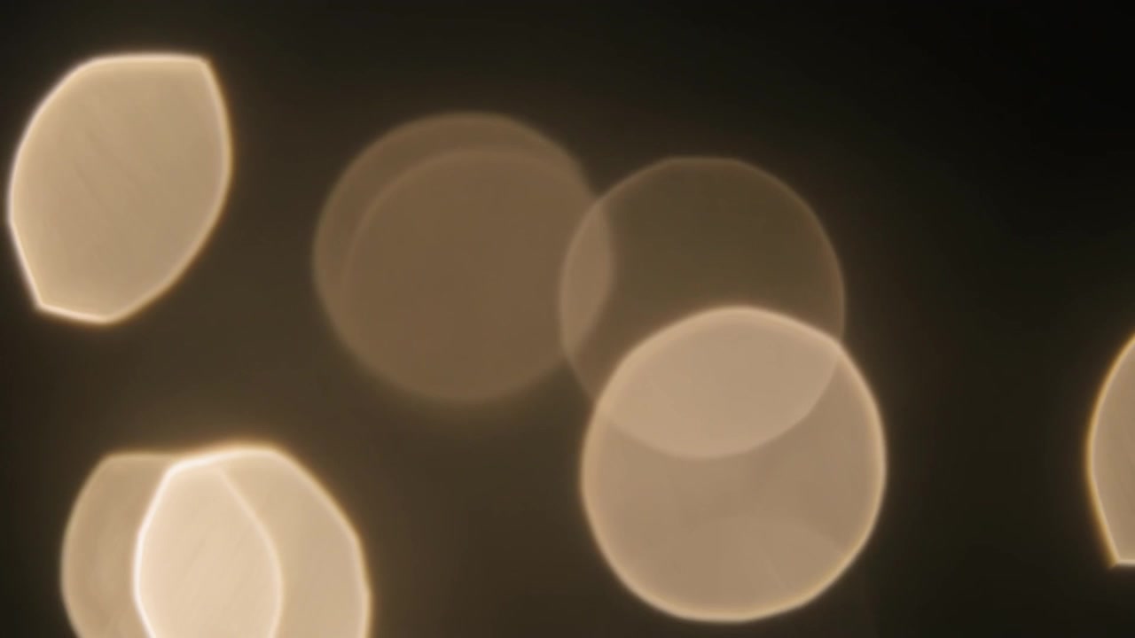 Abstract Golden Bokeh Lights Shimmering on Dark Background