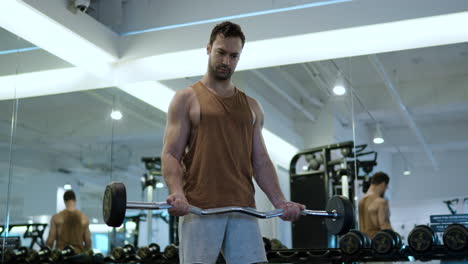 Hombre-En-30-Levantando-Peso-Realizando-Ejercicio-De-Curl-De-Bíceps-En-El-Gimnasio-Interior-De-Pie-Junto-A-Los-Espejos---Cámara-Lenta