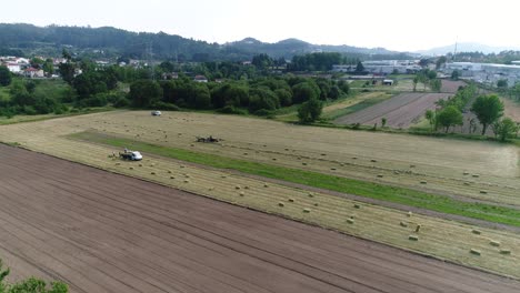 Heuhaufen-Auf-Dem-Feld-Und-Traktor,-Der-Auf-Dem-Natürlichen-Grünen-Hintergrund-Arbeitet