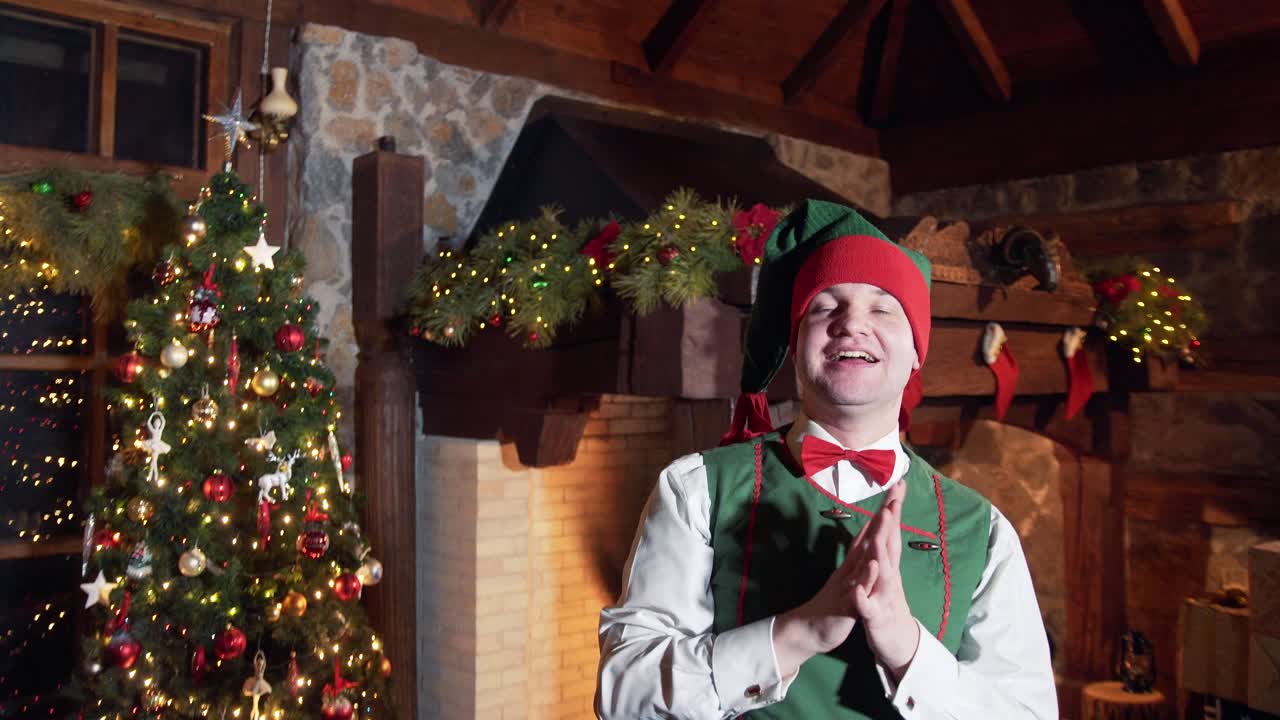 Happy elf takes adieu to Santa. Portrait of an elf waving bye on Christmas tree background in Santa's residence. Happy winter holidays