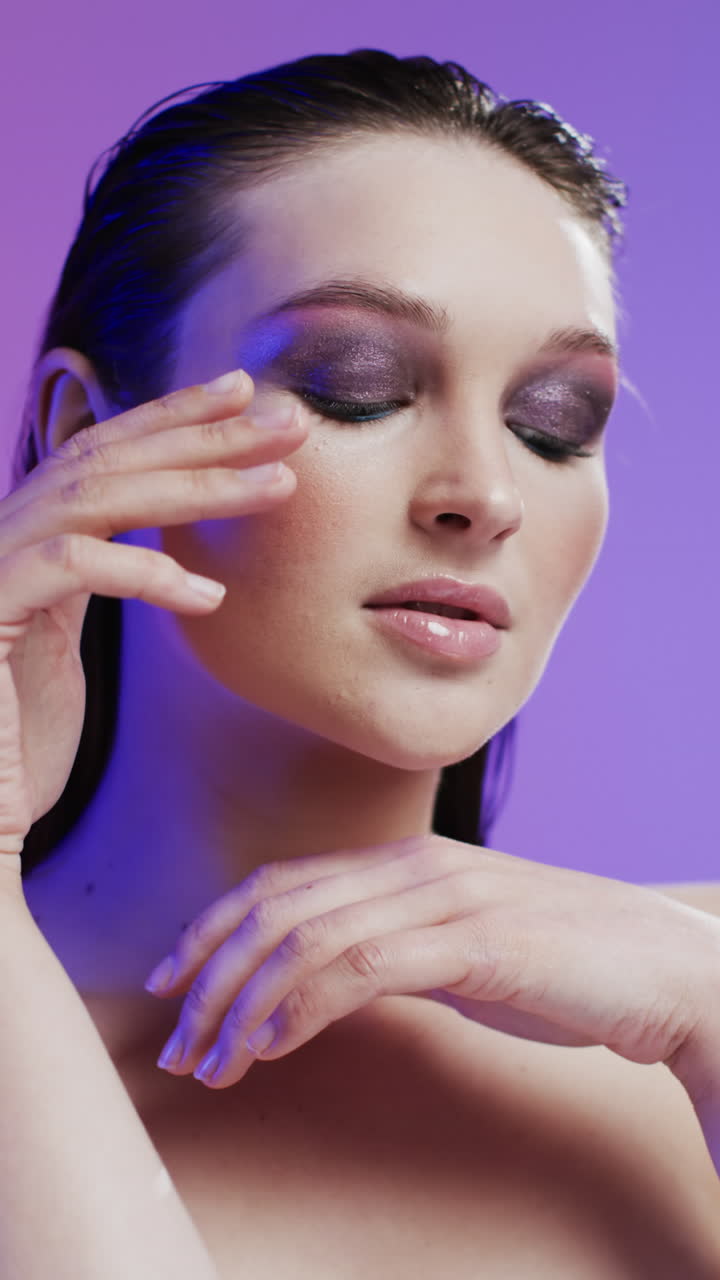 Video verticale di donna caucasica con capelli castani e trucco che si tocca il viso, spazio per la copia, rallentatore