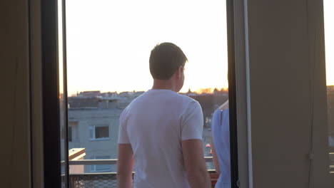 man and woman looking at the city from balcony