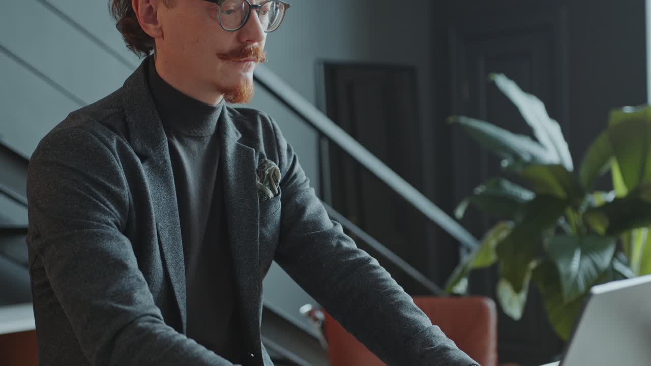 Concentrated Businessman Typing on Laptop at Office Workplace