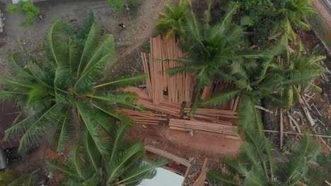 Toma-Ascendente-De-Un-Hombre-Lijando-Tablones-De-Madera-En-La-Construcción-De-Un-Barco-En-Belitung,-Aéreo