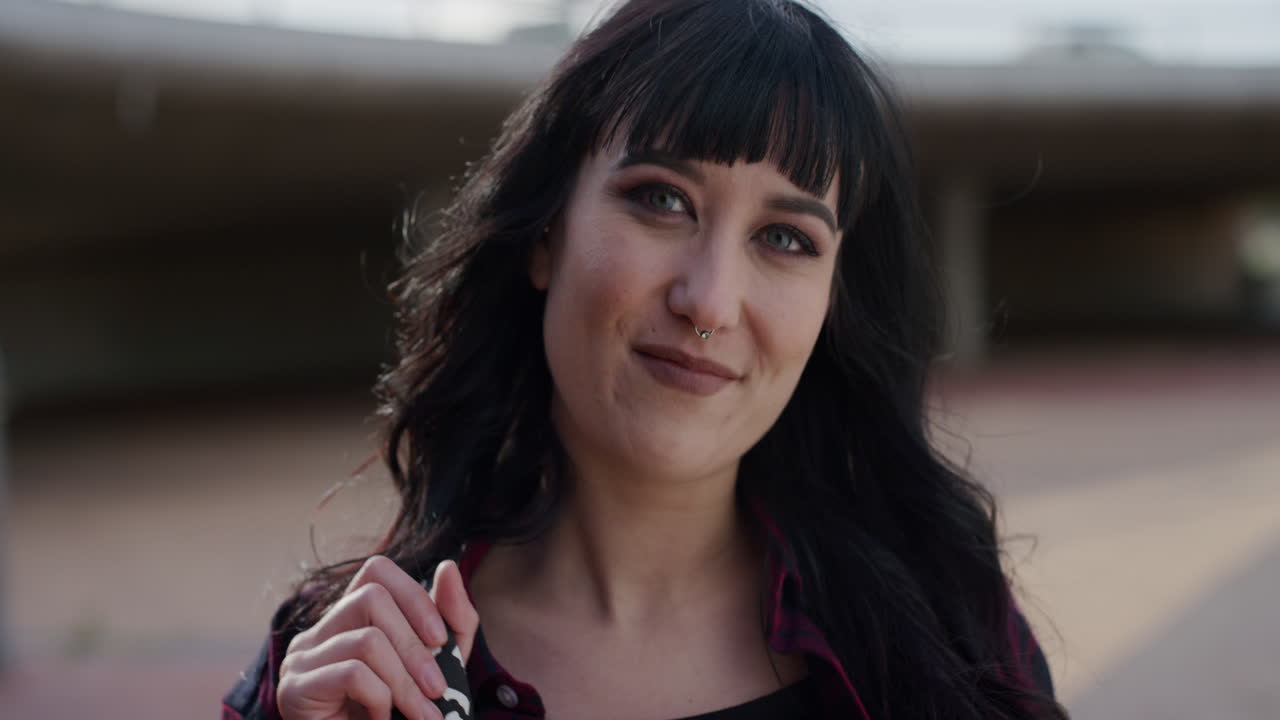 retrato de cerca de una mujer joven independiente y segura de sí misma mirando a la cámara en cámara lenta de fondo urbano