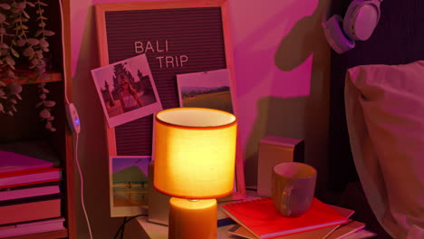 cozy bedroom nightstand with bali trip photos and pink lights