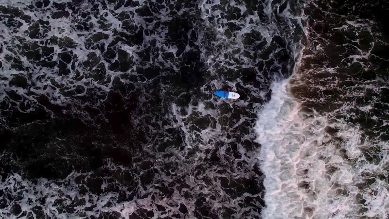 Top down zenithal drone view of ocean surface with a small boat floating near Tenerife coast