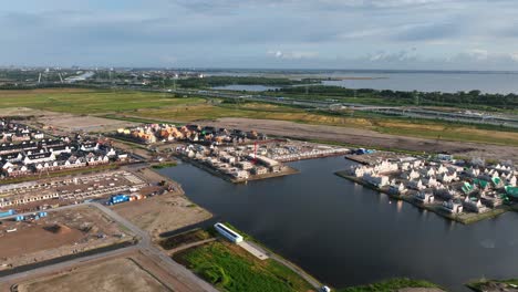 Aerial-view-of-a-large-housing-project-construction-site-by-the-river-in-Amsterdam,-Weesp,-Netherlands