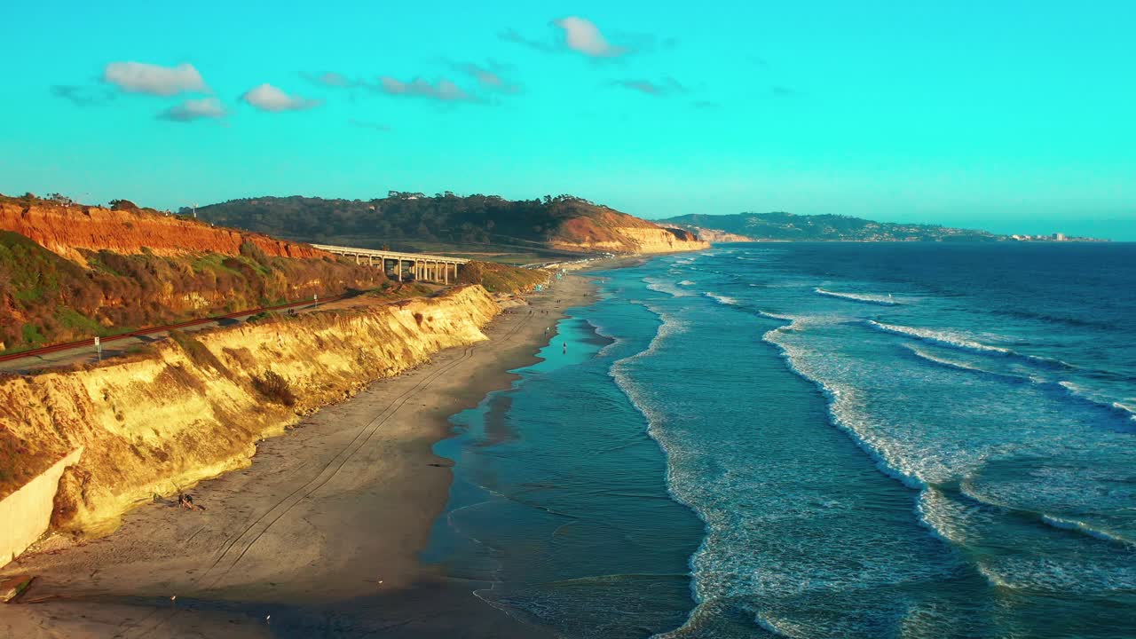 Aerial view of the bluffs and train tracks in Del Mar just before sunset with Torrey Pines and La Jolla in the distance. Wider of 2