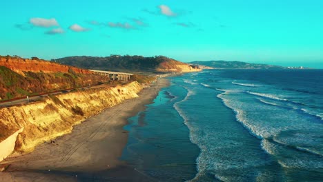 aerial view of the bluffs and train tracks in del mar just before sunset with torrey pines and la jolla in the distance. wider of 2
