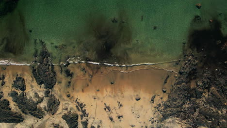 drone looking over the beach with waves sweeping into the beach