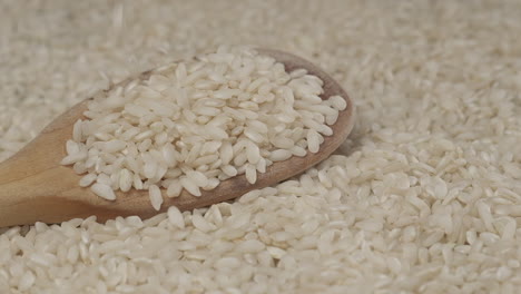 White-rice-cereal-falling-slow-motion-wooden-spoon