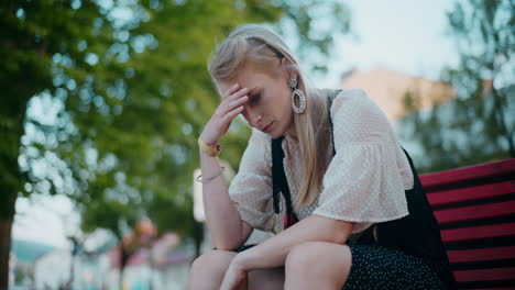 woman sitting on a bench, looking depressed