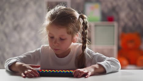 tranquil girl with abacus solves tasks sitting at workplace