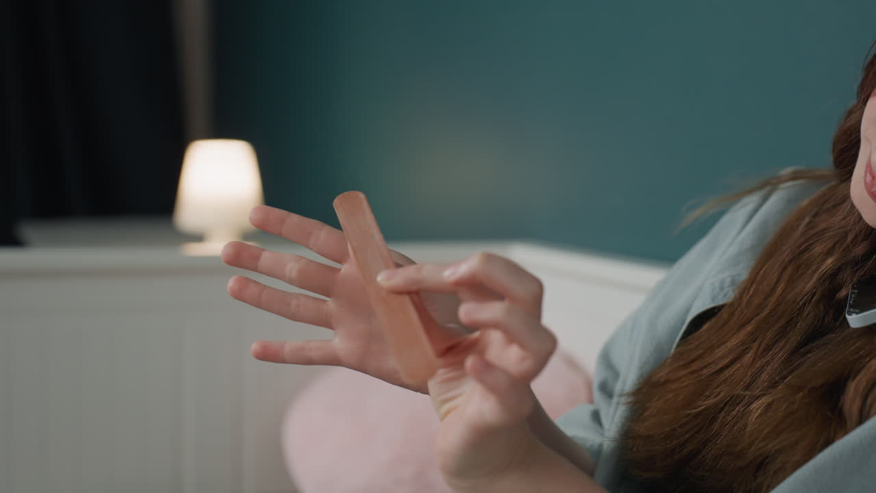 Evening selfcare with gentle nail filing. Cozy teal room as young woman cares for nails peacefully. Young woman in teal room performs soothing evening nail grooming routine with gentle touch
